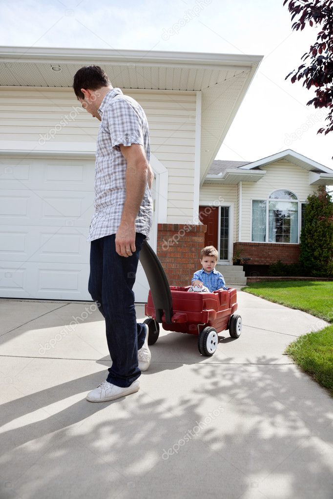 Father Pulling Son Sitting in Wagon