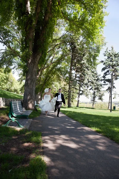 Recém-casado correndo ao longo da passarela — Fotografia de Stock