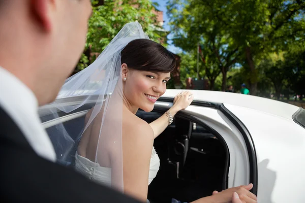 Невеста садится в лимузин — стоковое фото