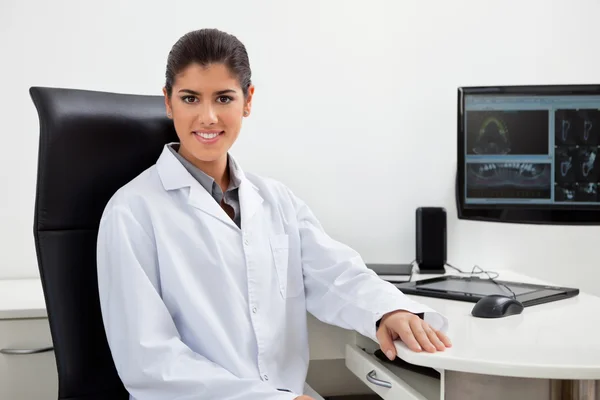 Vrouwelijke tandarts zit op haar Bureau — Stockfoto
