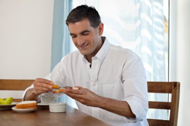 Smiling Man Having Breakfast clipart