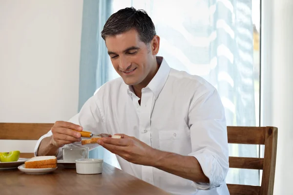 Hombre sonriente desayunando — Foto de Stock
