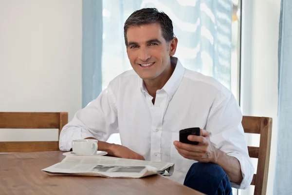 Mann mittleren Alters hält Handy in der Hand — Stockfoto