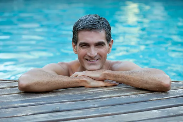 Homem Relaxante pela borda da piscina — Fotografia de Stock