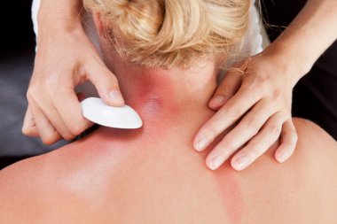 Woman Receiving GuaSha Treatment on Neck clipart