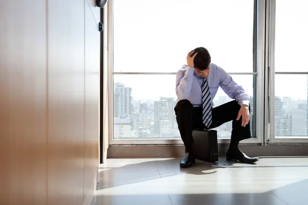 Boos zakenman zittend op werkmap — Stockfoto