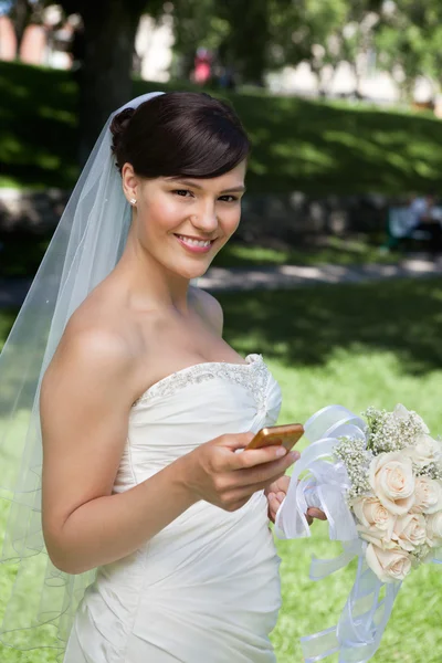 Noiva recém-casada segurando celular — Fotografia de Stock