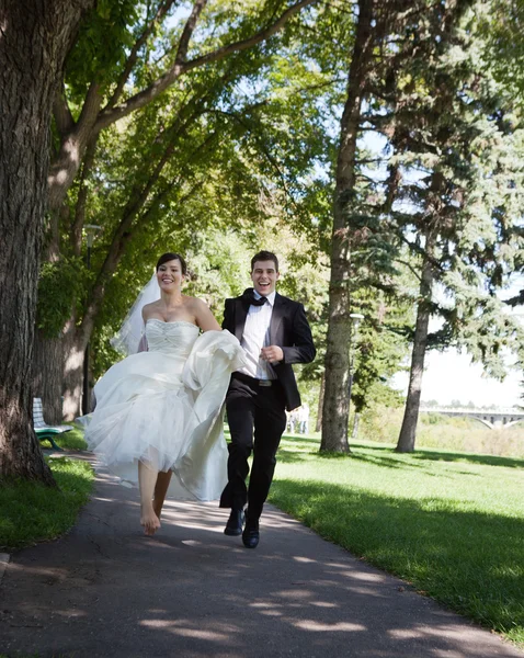 Noiva e noivo correndo — Fotografia de Stock