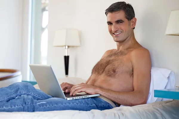 Shirtless homem trabalhando no laptop — Fotografia de Stock