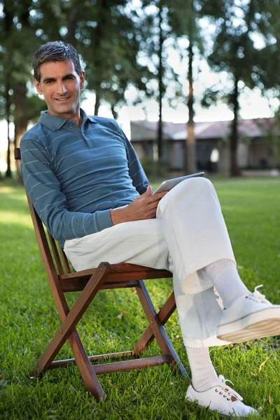 태블릿 pc와 함께 공원에 앉아있는 캐주얼 남자 — 스톡 사진