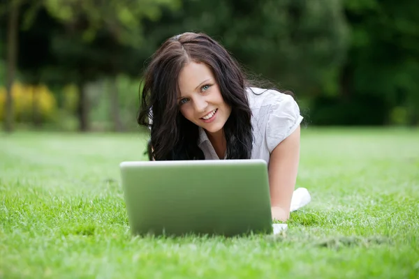 Casual θηλυκό χρησιμοποιώντας φορητό υπολογιστή στο πάρκο — Φωτογραφία Αρχείου
