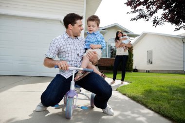 Playful Father Sitting on Tricycle With Son clipart