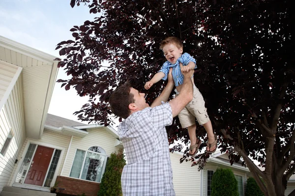 Отец поднимает сына в воздух — стоковое фото