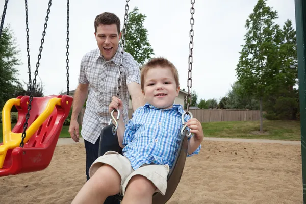 Far och son på lekplats — Stockfoto