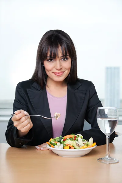 Executivo feminino comer salada de legumes frescos — Fotografia de Stock