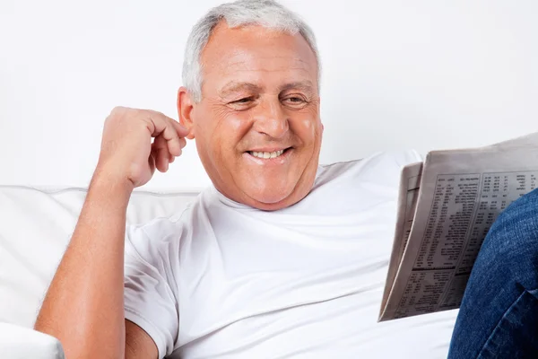 Starší muž čte doma noviny — Stock fotografie