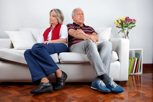 Пара сидящих на диване после ссоры — стоковое фото