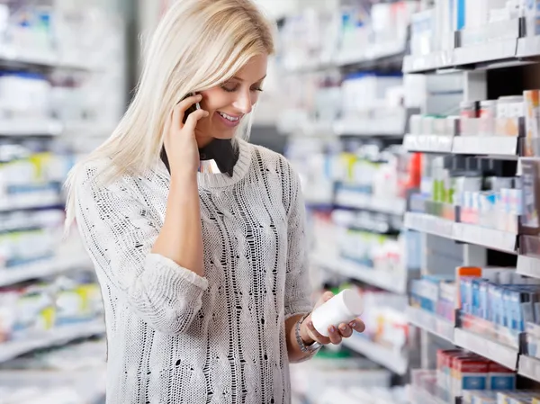 Γυναίκα στο φαρμακείο που μιλάει στο τηλέφωνο — Φωτογραφία Αρχείου