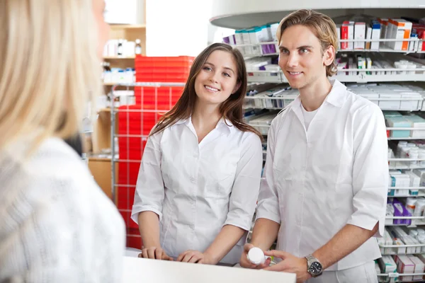Фармацевти з клієнтом в магазині — стокове фото