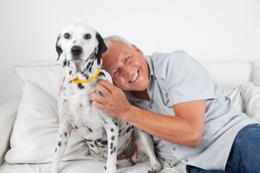 Senior Man Sitting With His Pet Dog clipart