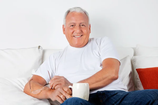 Avslappnad senior man har med varm dryck — Stockfoto