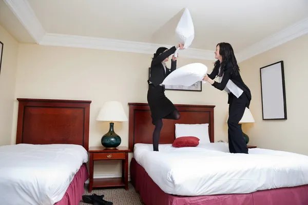 Executivos femininos jogando travesseiro luta — Fotografia de Stock