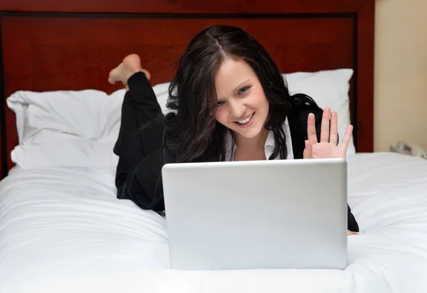 Geschäftsfrau liegt mit Laptop im Bett — Stockfoto