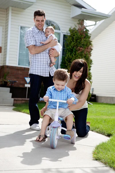 Mãe alegre que ensina o filho a montar triciclo — Fotografia de Stock