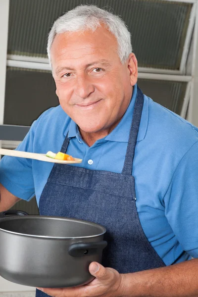Uomo degustazione cibo da cucchiaio — Foto Stock