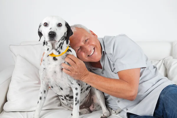 Homme âgé assis avec son chien de compagnie — Photo