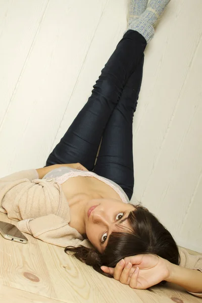 Mladá žena leží na podlaze v domě — Stock fotografie