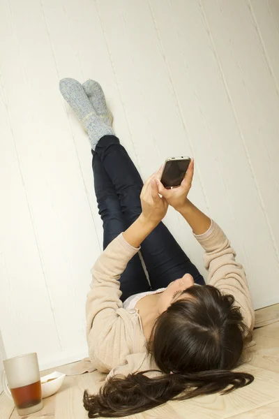 Mladá žena leží na podlaze v domě — Stock fotografie