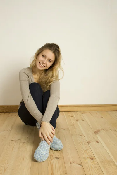 Young woman sitting on the floor at home — Stock Photo, Image