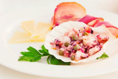 Octopus salad served with cheese and prosciutto on the side clipart