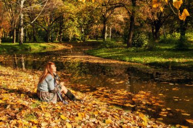 Woman sitting in the park clipart