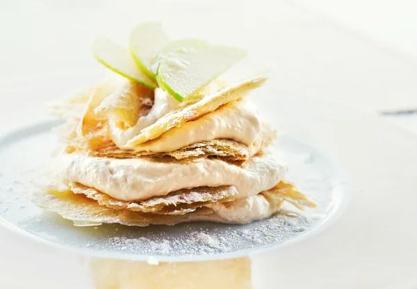 Десерт с лимоном и ванильным кремом, украшенный яблочными ломтиками — стоковое фото