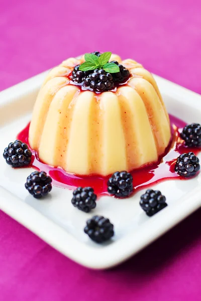 Vanilla pudding on a plate decorated with blackberries and mint — Stock Photo, Image