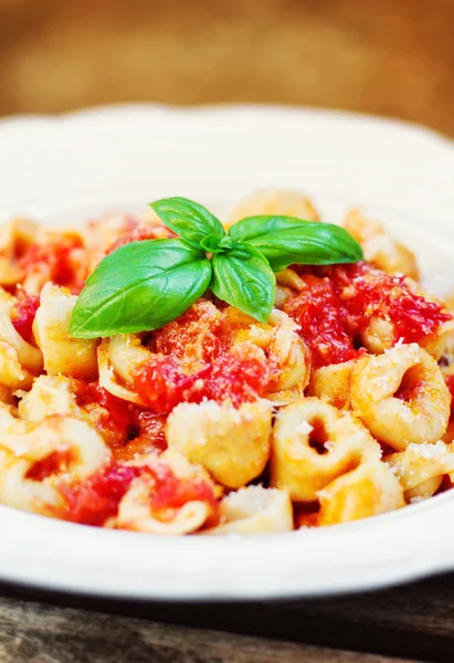 Tortellini avec sauce tomate sur une assiette, décorée de basilic — Photo