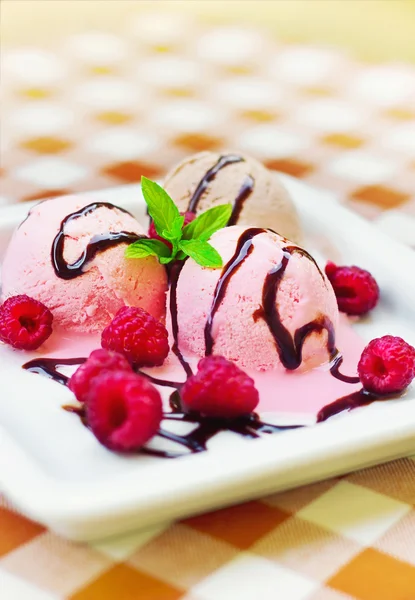 Ice cream in a plate decorated with mint and raspberries — Stock Photo, Image