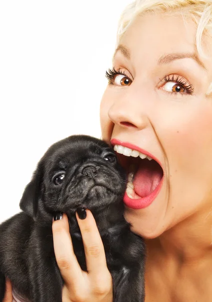 Cute blonde playing with a pug puppy — Stock Photo, Image