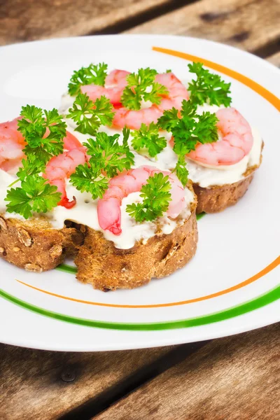 Shrimp crostini with parsley on a plate — Stock Photo, Image