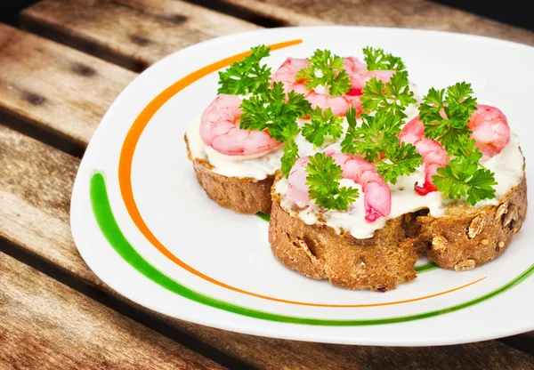 Shrimp crostini with parsley on a plate — Stock Photo, Image