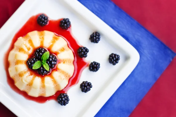 Vanilla pudding on a plate decorated with blackberries and mint — Stock Photo, Image