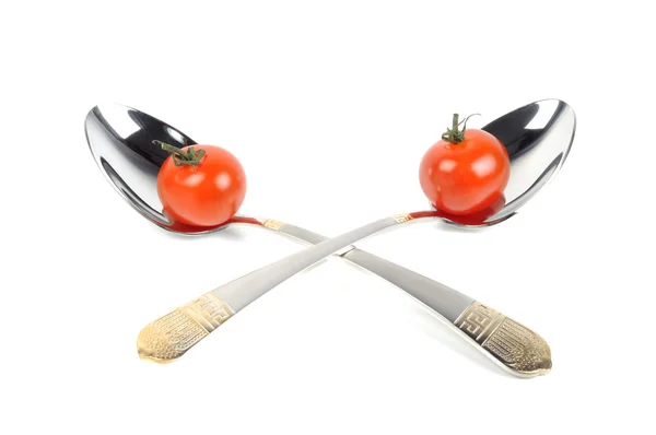 Two metal spoons with tomatos — Stock Photo, Image