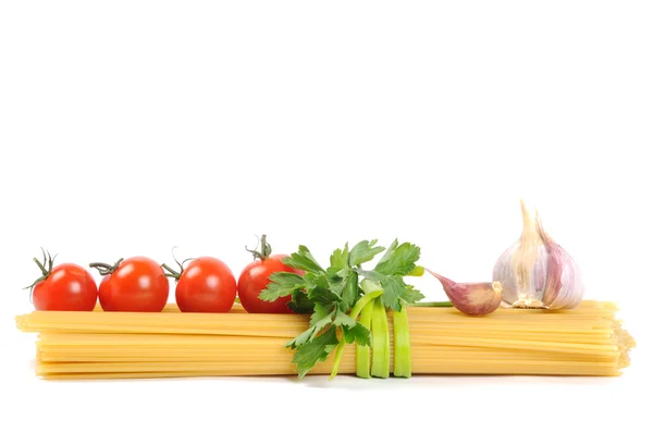 Bunch of raw apaghetti with garlic and tomato — Stock Photo, Image