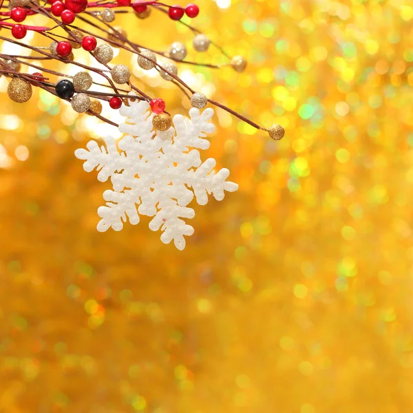 Fondo navideño con copo de nieve, baya roja y bokeh dorado —  Fotos de Stock