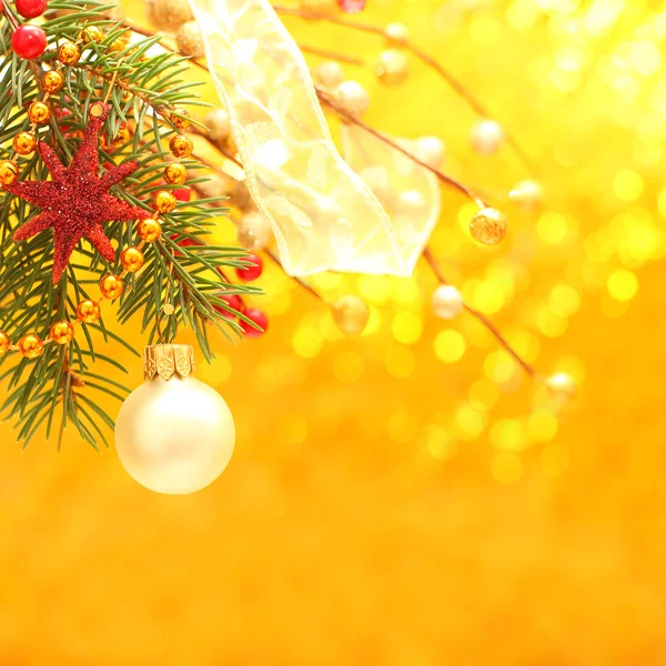 Рождество - золотой фон с декором, лентой и мячом — стоковое фото