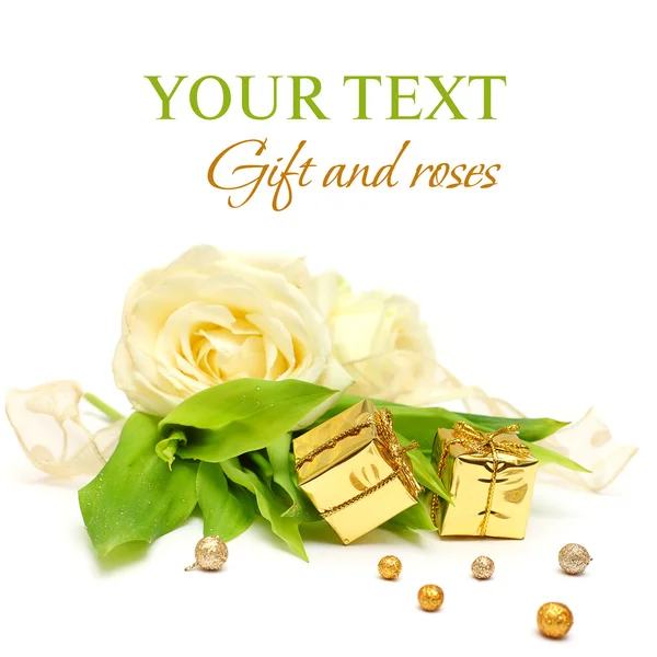 Dárek, květy růže a zlatá stuha na bílém - luxusní pozadí — Stock fotografie