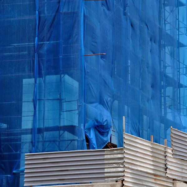 Building under debris netting at construction site — Stock Photo, Image