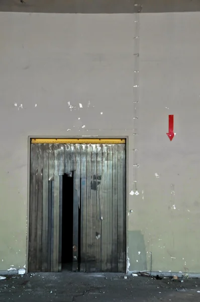 Door and arrow sign in industrial interior — Stock Photo, Image